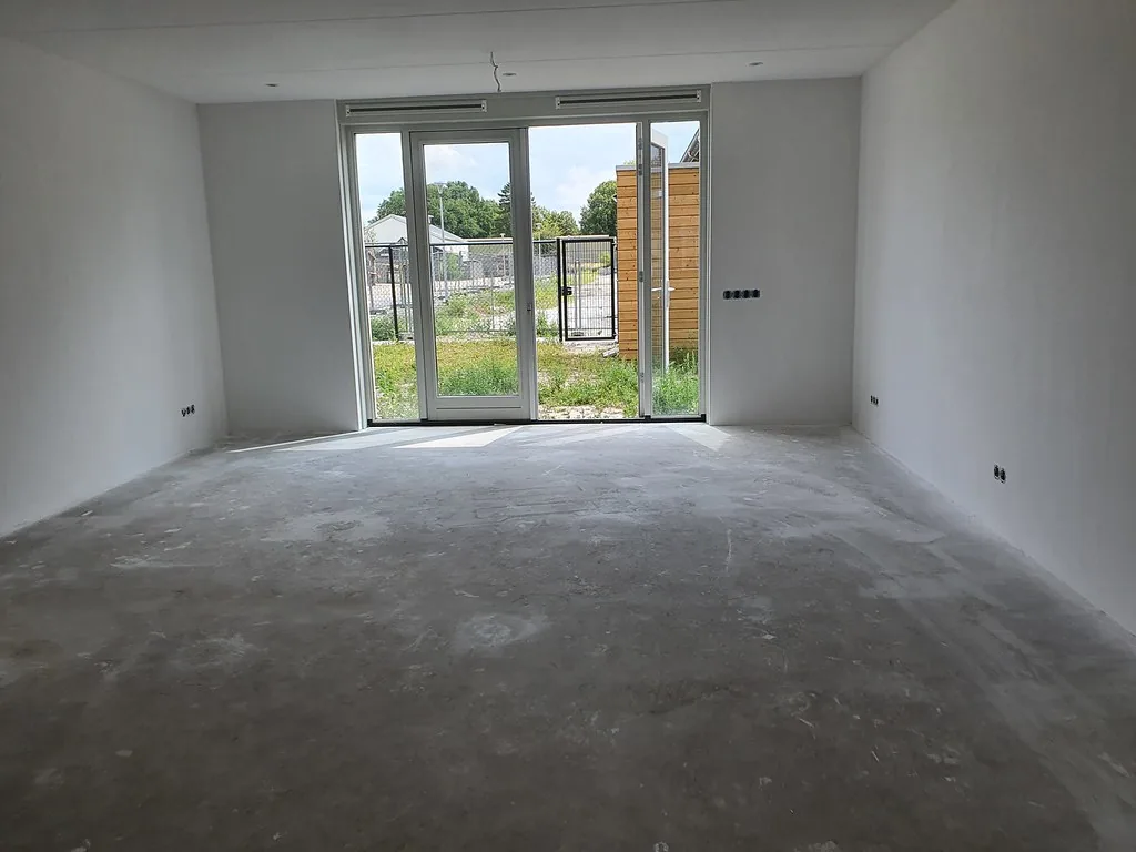 Nieuwbouwkamer met grote raampartij, wanden en plafond glad afgewerkt met dunpleister